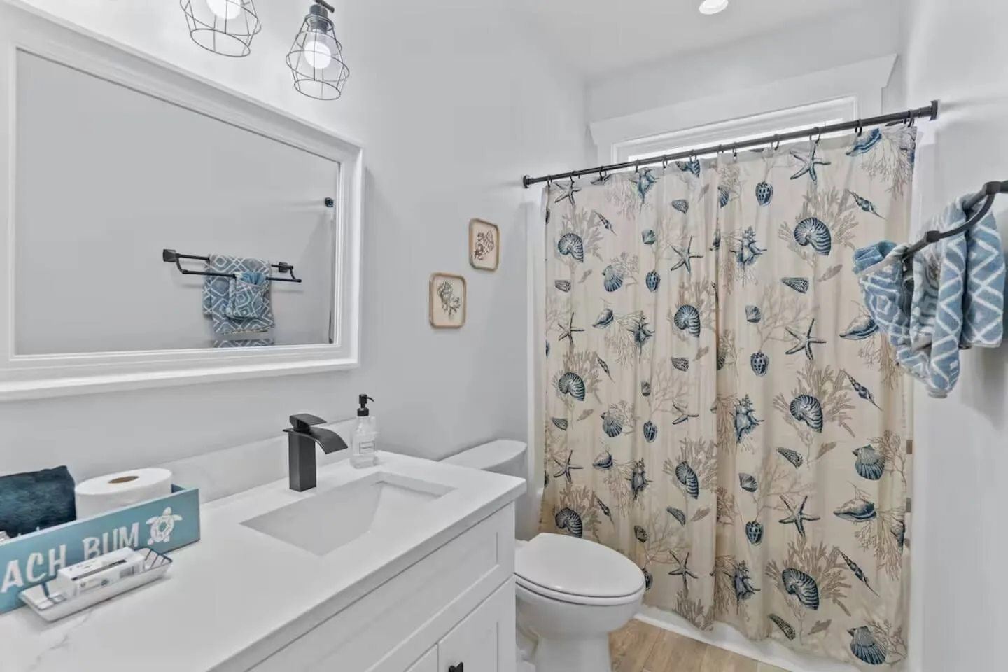 Second full bathroom with a seashell shower curtain and single vanity